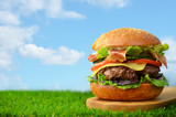 Burger with bacon on grass