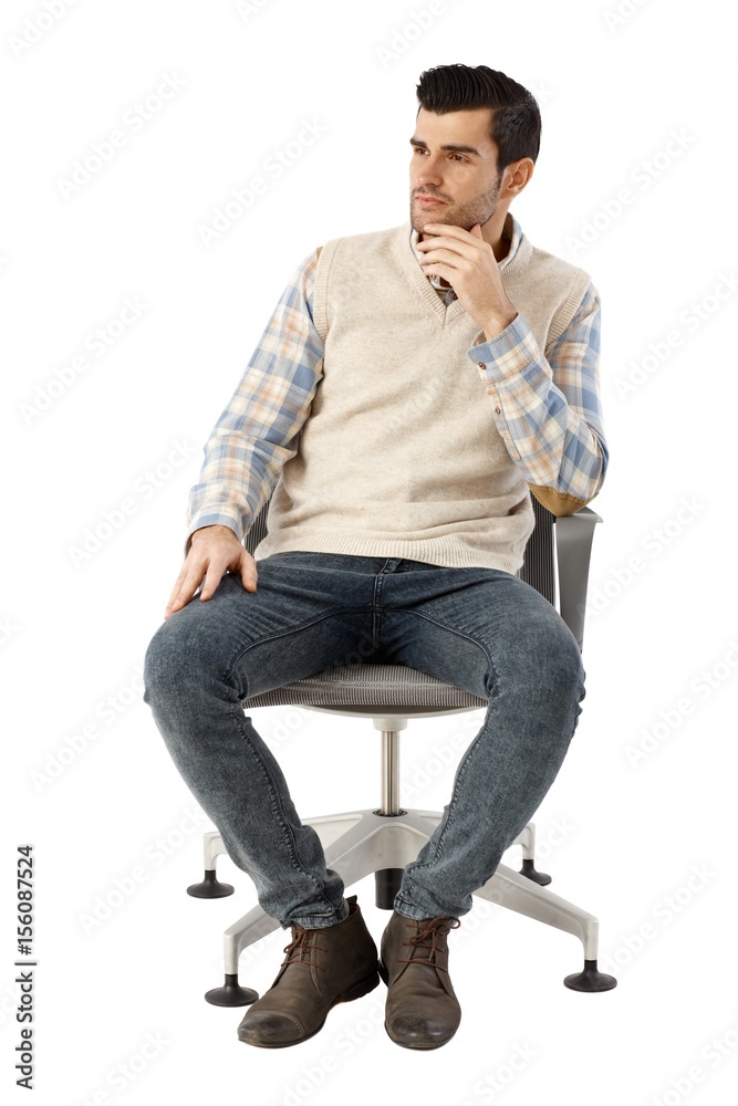 Young man sitting in swivel chair thinking Young man sitting in swivel chair thinking