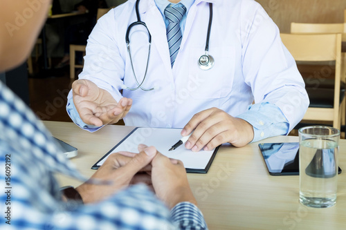 Konstfotografi patient listening intently to a male doctor explaining patient symptoms or askin