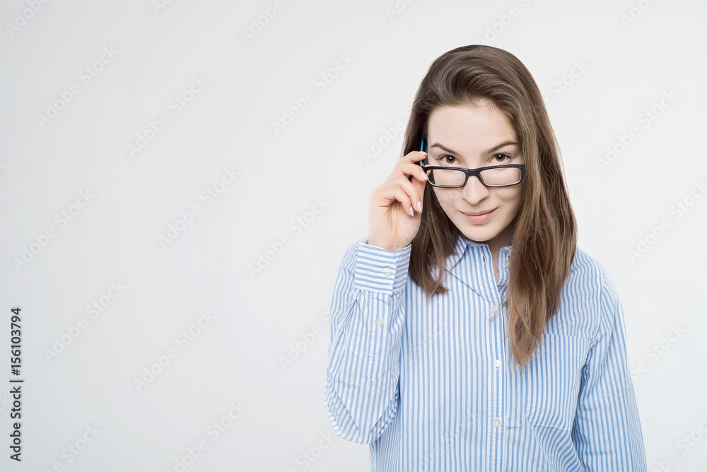 Pretty young girl touches glasses looks at camera Pretty young girl touches glasses looks at camera
