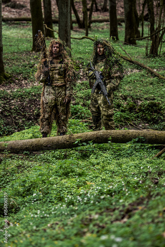 Camouflaged soldiers in forest