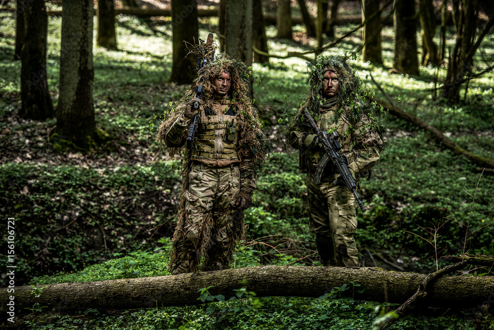 Camouflaged soldiers in forest