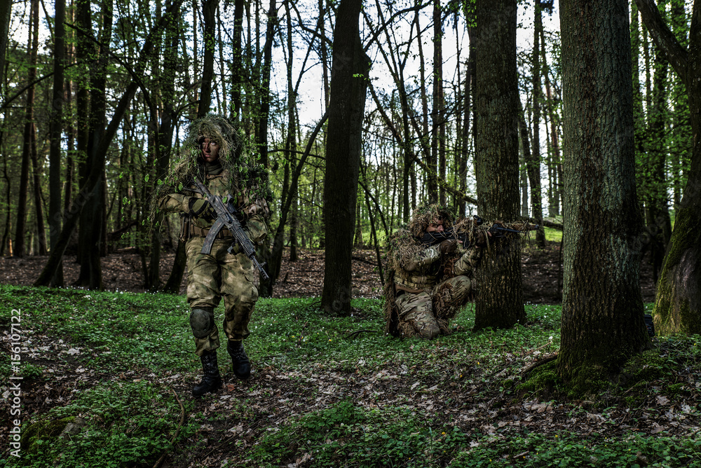 Camouflaged soldiers in forest