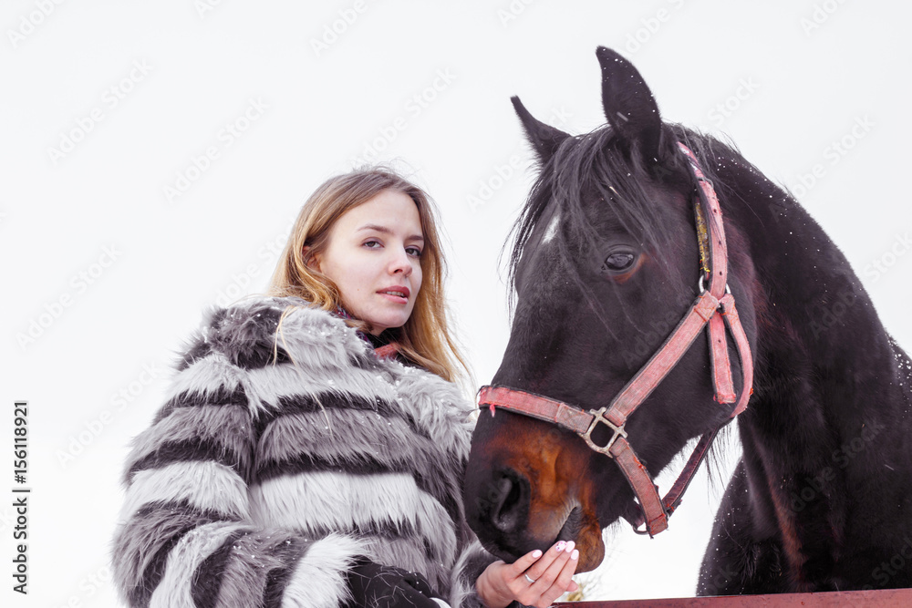 Fototapeta premium Nice girl and horse outdoor in a winter