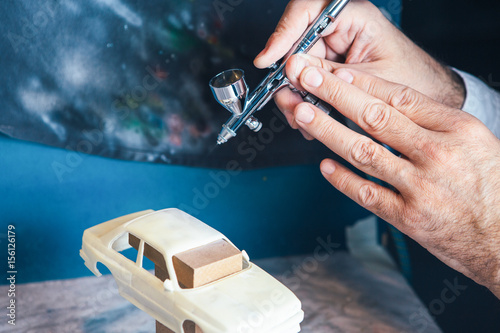 Fotografie Person painting slot car with aerograph