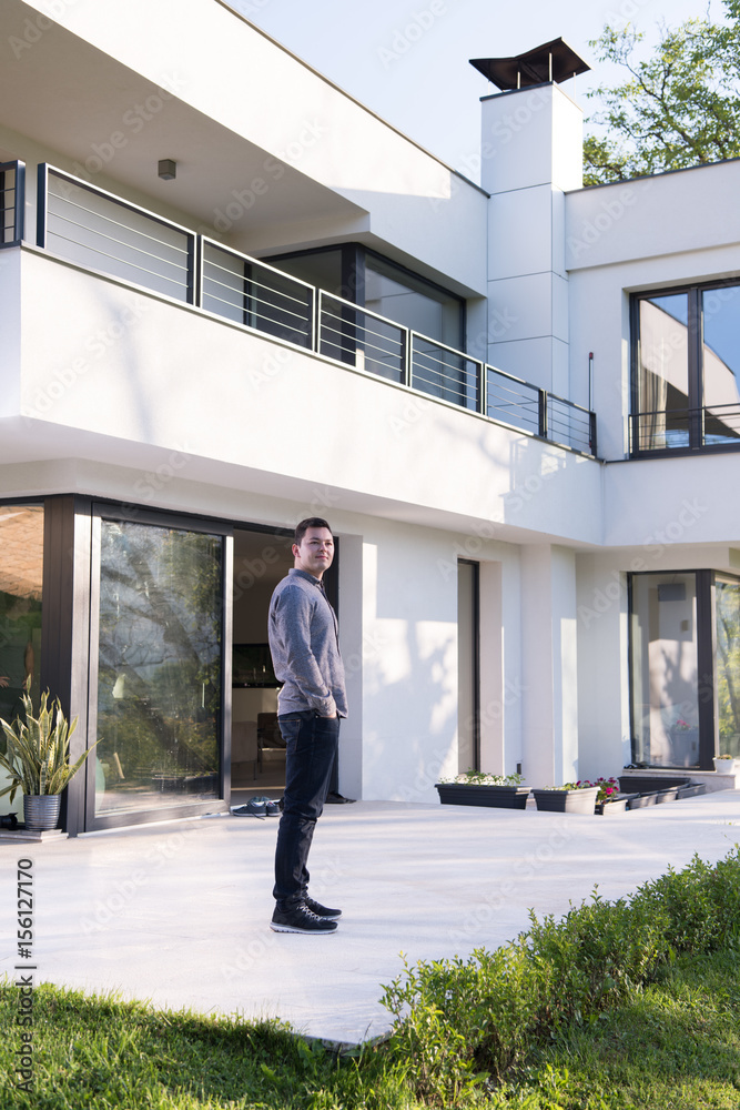 man in front of his luxury home villa