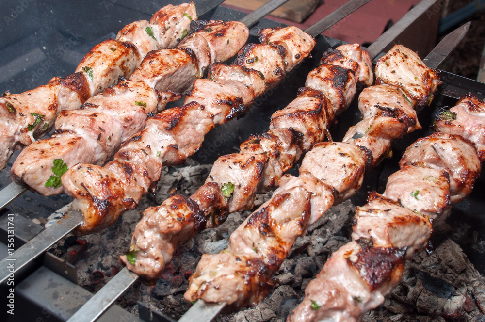 Extremely fried marinated meat on skewers over coals