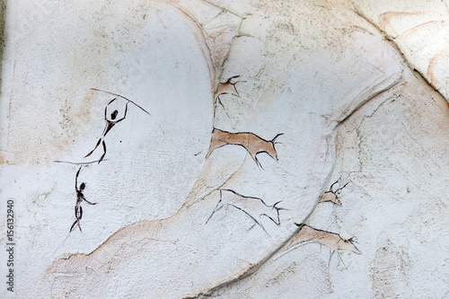Concept painted on a rock, ancient people hunt animal buffalo with a spear