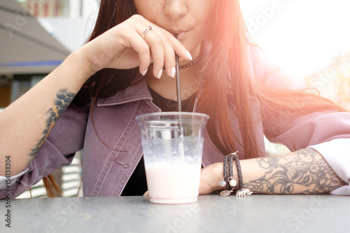 young pretty brunette woman drinking milky cocktail