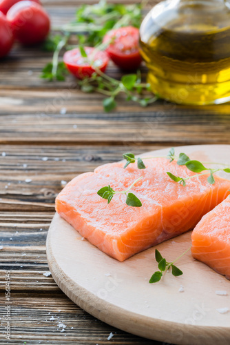 Raw uncooked salmon and vegetables on wooden table