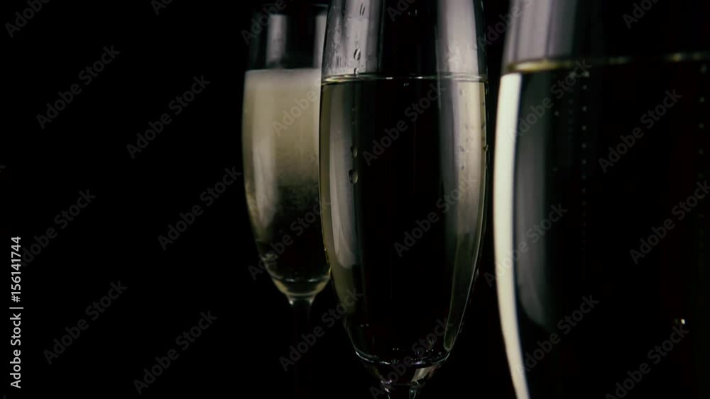 In three filled glasses with champagne two strawberries fall. Slow mo In three filled glasses with champagne two strawberries fall. Slow mo