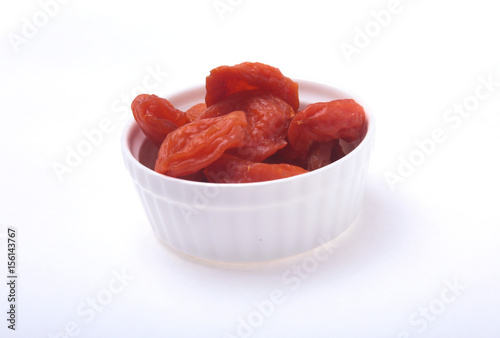 Delicious dried organic apricots on bowl isolated over white background.