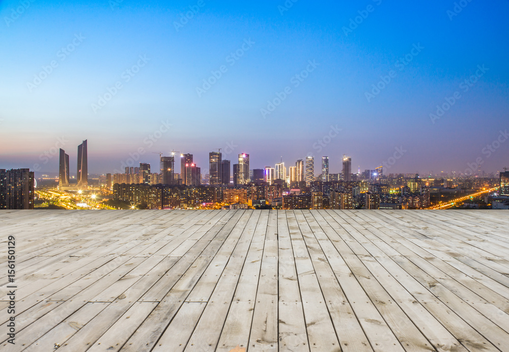 Panoramic skyline and buildings with empty concrete square floor at night Panoramic skyline and buildings with empty concrete square floor at night