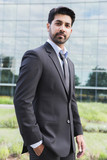 Businessman or worker standing in suit near office building