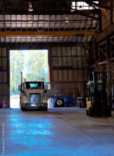 Semi truck entering old antic building warehouse unloading cargo