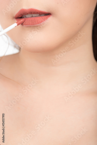 Cosmetic beauty procedures lipstick on lips of young woman
