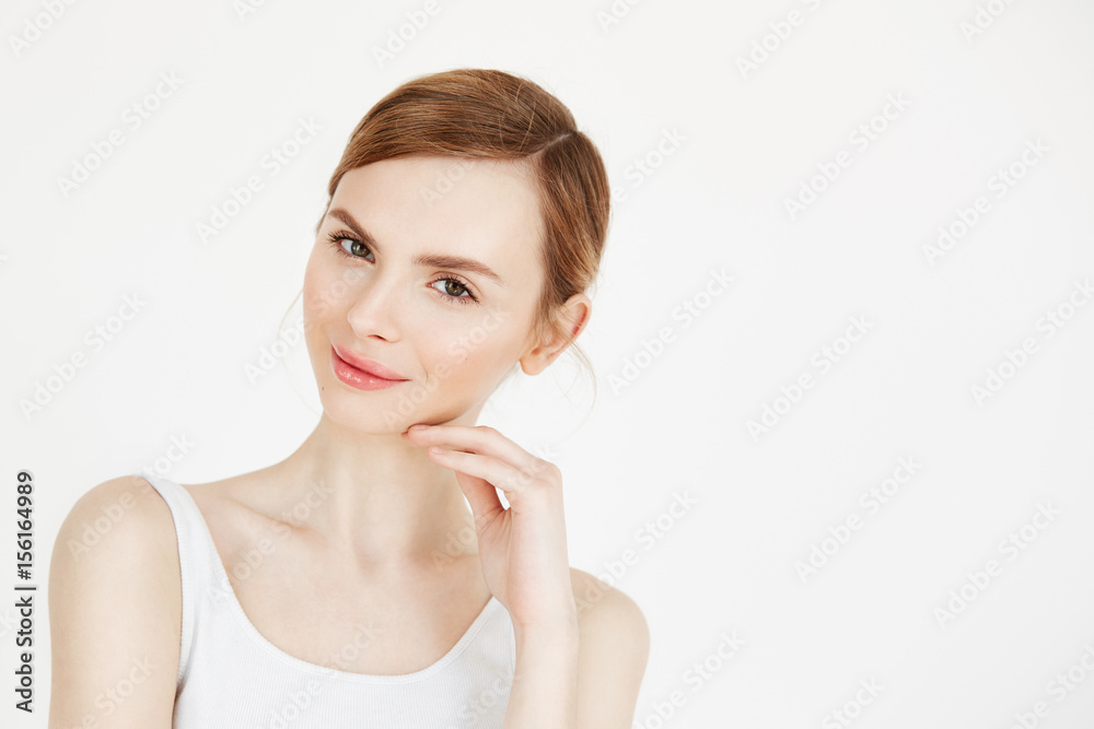 Portrait of young beautiful girl with natural make up smiling looking at camera over white background. Health and beauty lifestyle. Portrait of young beautiful girl with natural make up smiling looking at camera over white background. Health and beauty lifestyle.