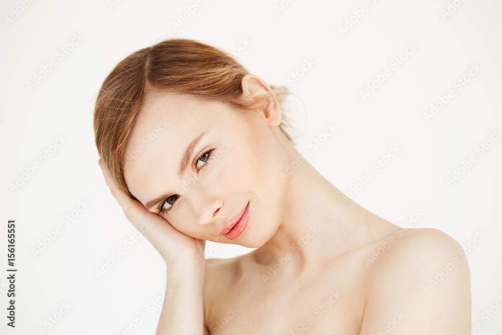 Portrait of young beautiful girl looking at camera touching face over white background. Facial treatment. Beauty cosmetology and skincare. Portrait of young beautiful girl looking at camera touching face over white background. Facial treatment. Beauty cosmetology and skincare.