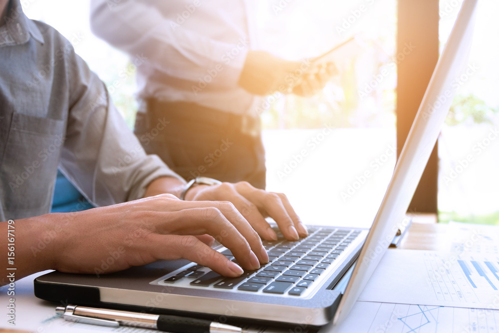 Cropped image of handsome businessmen using laptop at a office Cropped image of handsome businessmen using laptop at a office