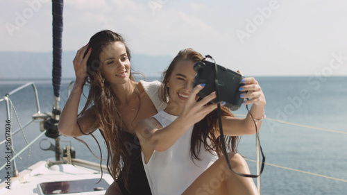 Best friends using camera and taking selfie on luxury sailing boat selfie © lovevision