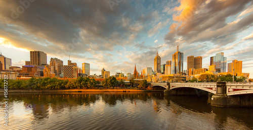 Melbourne City, Yarra River, Princes Bridge with Reflection Cityscape Skyline background under dramatic Golden Sky Sunset, Australia photo