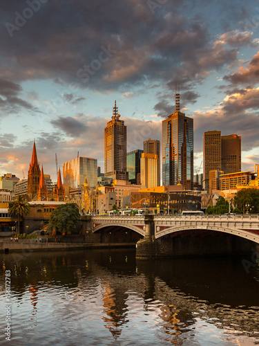 Melbourne City, Yarra River, Princes Bridge with Reflection Cityscape Skyline background under dramatic Golden Sky Sunset, Australia