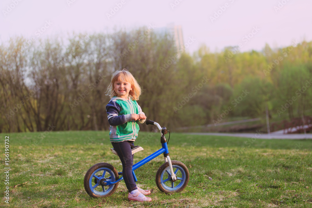 little girl riding bike in nature