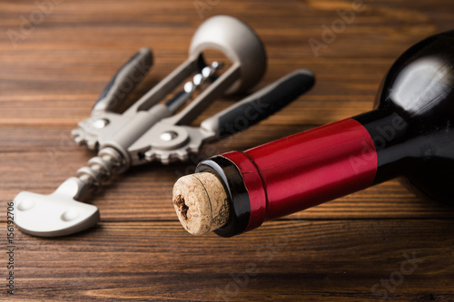 wine corkscrew and bottle on wooden table
