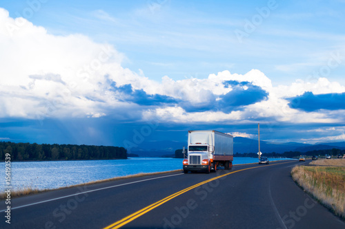 Fotografija Spectacular river view of road with semi truck and trailer