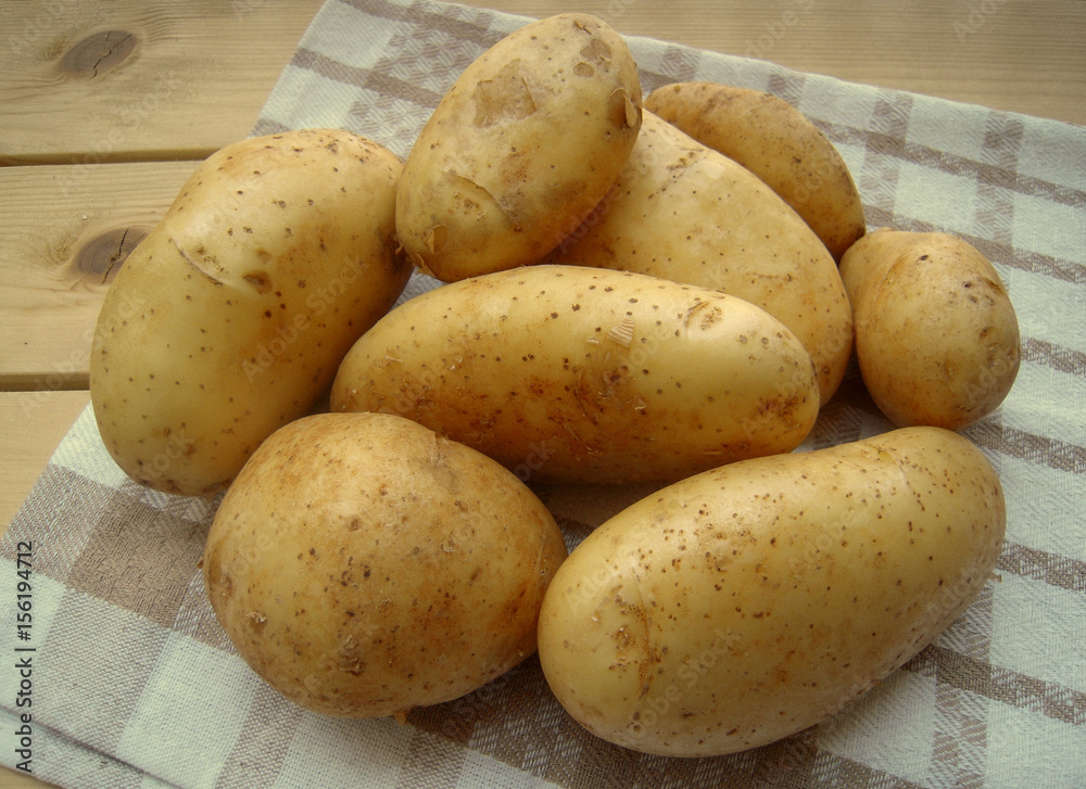 Raw potatoes on a kitchen towel Raw potatoes on a kitchen towel
