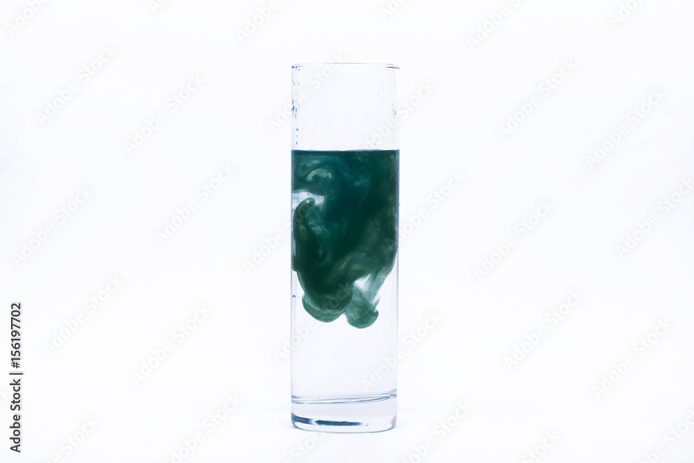 Blue paint falls in a glass with water Blue paint falls in a glass with water