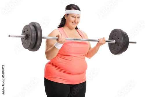 Overweight woman lifting a big dumbbell