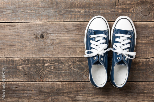 Blue sneakers on wooden background