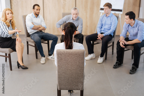 Pleasant nice people sitting on the chairs