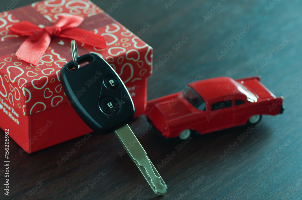 Naklejka premium key of car in gift box on wood table