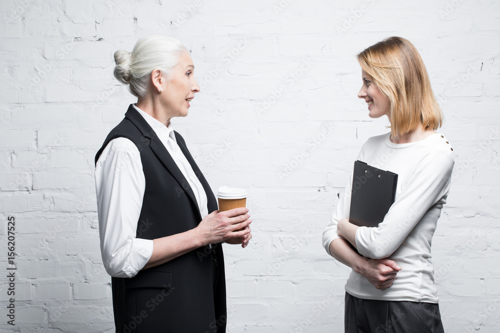 side view of business people discussing work together side view of business people discussing work together