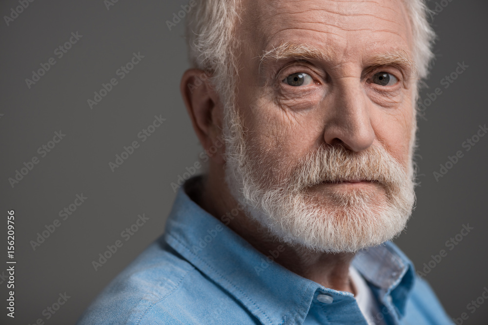 portrait of senior bearded man isolated on grey in studio portrait of senior bearded man isolated on grey in studio