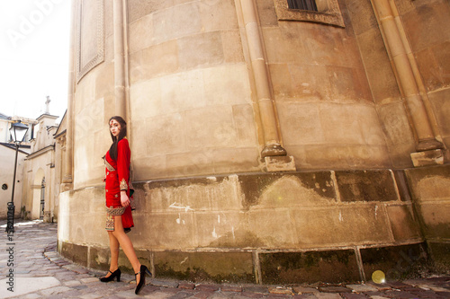 Girl in red Indian dress poses before old church on the street © IVASHstudio