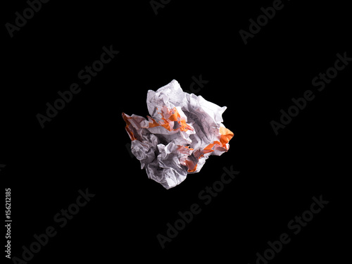 Crumpled piece of white blank squared paper exercise book on black background. photo