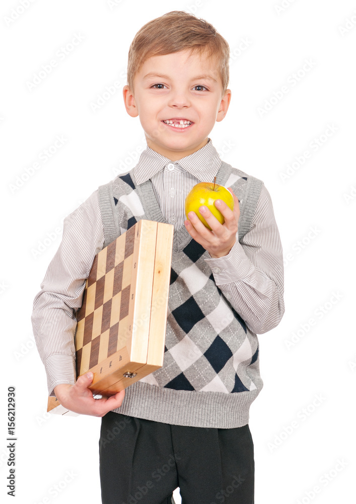 Emotional portrait of caucasian little boy with chessboard and apple. Funny child holding a game of chess in his arms while laughing. Cute smart kid, isolated on white background. Emotional portrait of caucasian little boy with chessboard and apple. Funny child holding a game of chess in his arms while laughing. Cute smart kid, isolated on white background.