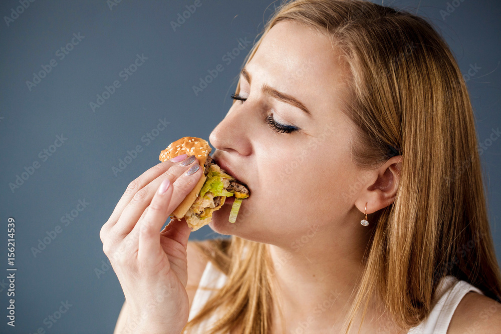 Woman with obesity eats delicious hamburger Woman with obesity eats delicious hamburger