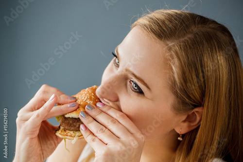 Woman with obesity eats delicious hamburger