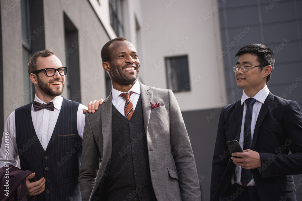 young stylish multiethnic businessmen in formalwear walking outdoors, business team meeting young stylish multiethnic businessmen in formalwear walking outdoors, business team meeting