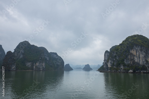 Vietnam Island Cat ba Halong. Group of rocky islands covered with vegetation in azure sea. Sand beach. Blue cloudless sky