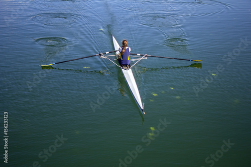 Young woman rowing in boat on the lake