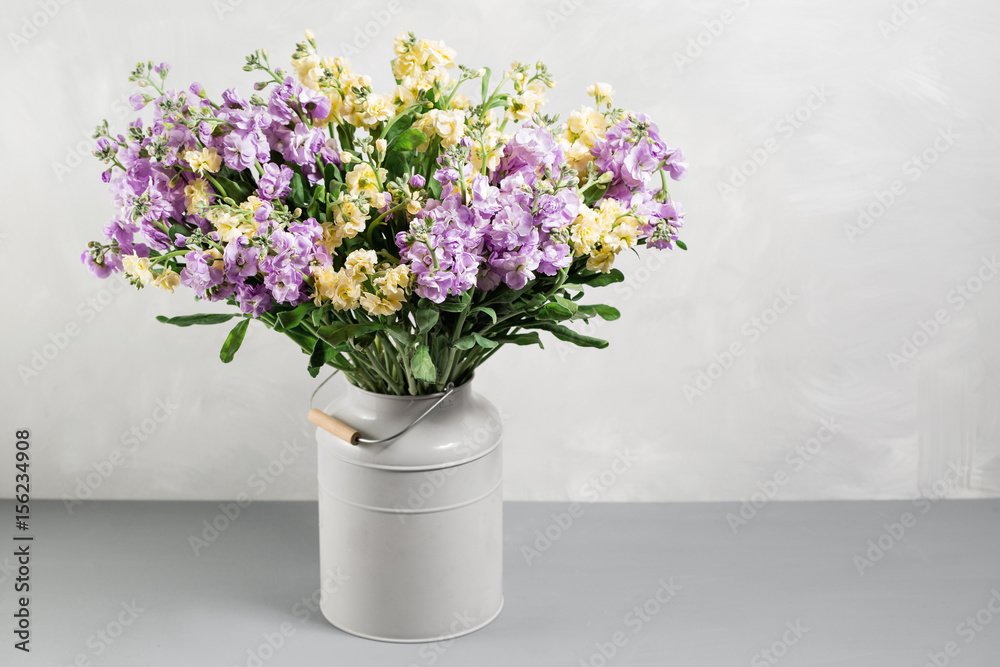 Bouquet of lilac and lemon color flowers gillyflower in grey water can Bouquet of lilac and lemon color flowers gillyflower in grey water can