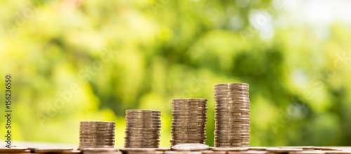 Photos coins stacks on table, nature background, money, saving and investment concept