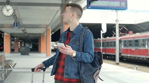 Worried man looking for the platform on the train station, steadycam shot
