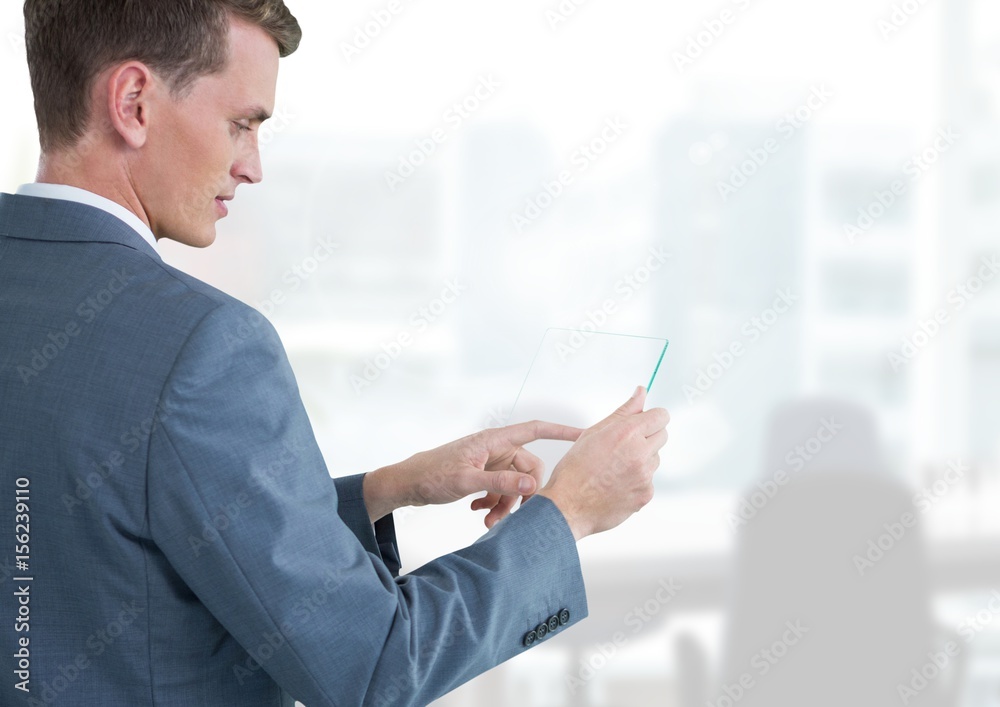 Businessman holding glass tablet in bright office Businessman holding glass tablet in bright office