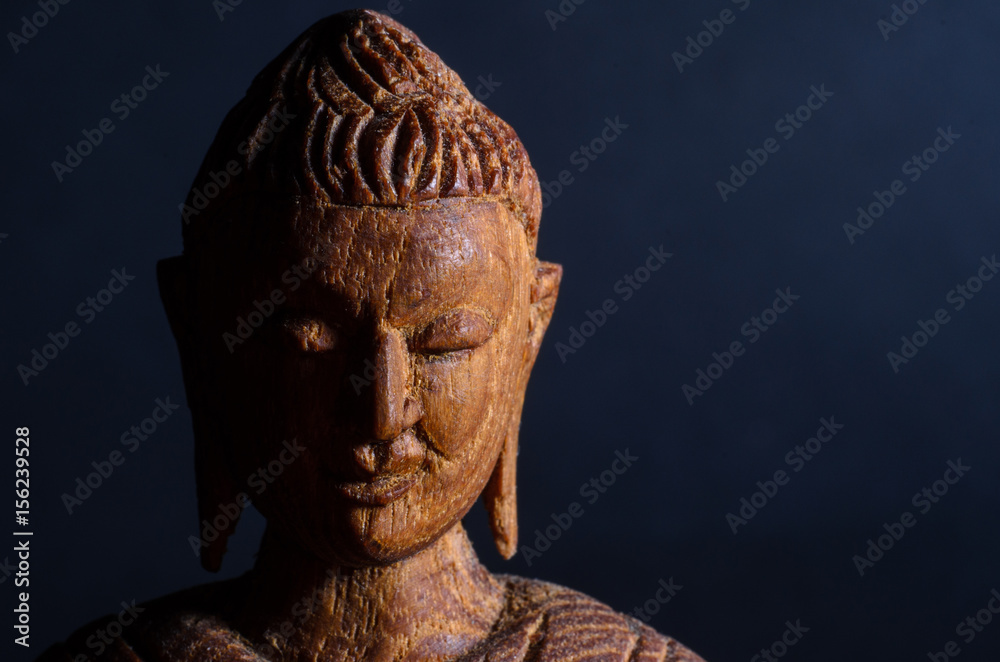 Wooden Buddha statue on a black background